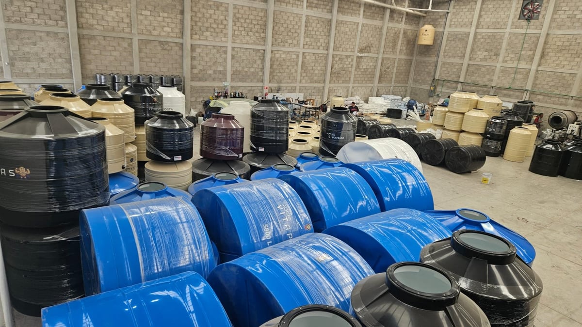 Blue and white industrial drums and barrels stored in a large warehouse