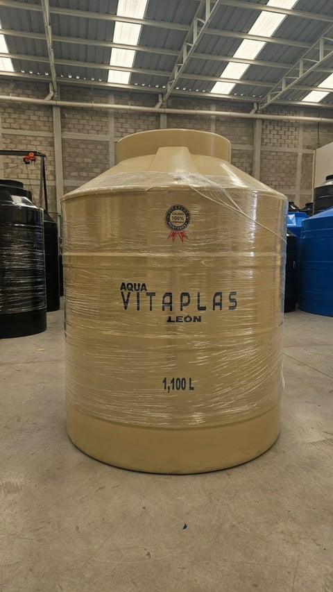 Large cream-colored cylindrical water storage tank labeled Aqua Vitaplas Leon with 1,100L capacity in an industrial warehouse