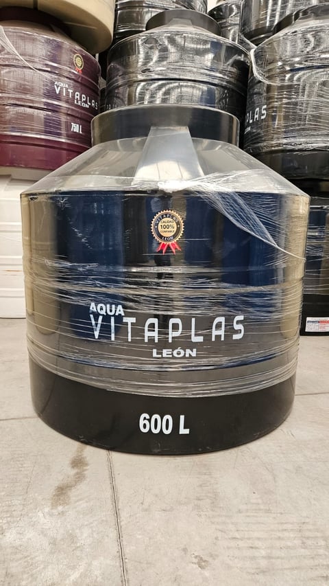 Large navy blue water storage tank labeled Aqua Vitaplas Leon with 600L capacity, wrapped in plastic, displayed in warehouse