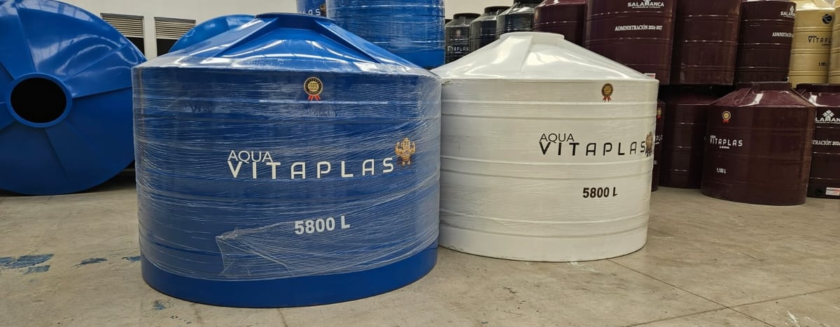 Large cylindrical water storage tanks branded Vitaplas in blue and white, showing 5800L capacity, displayed in an industrial yard